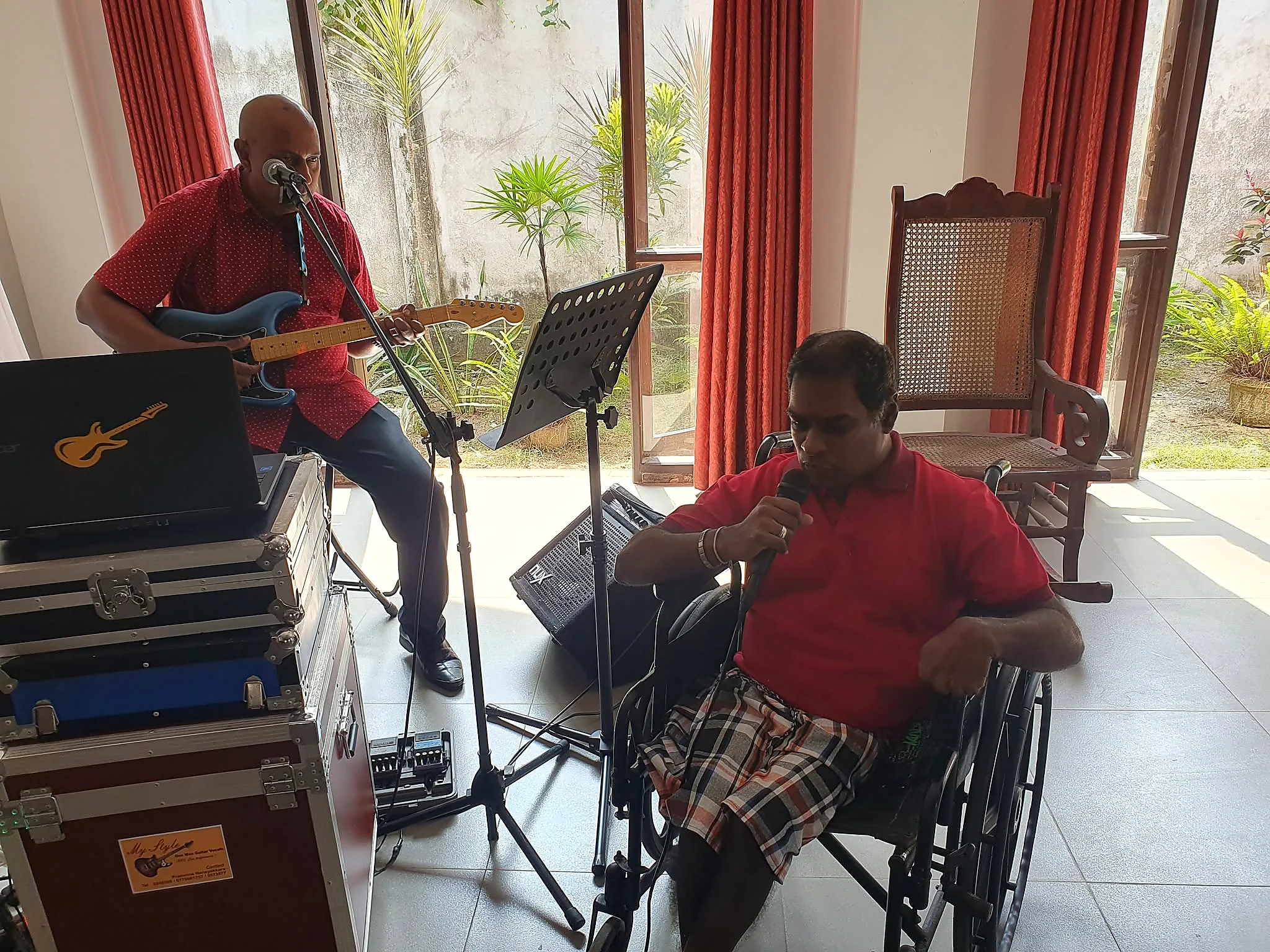 A resident singing while a guitarist performs